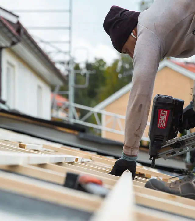 Takläggare arbetar med underlag och läkt under ett takbyte